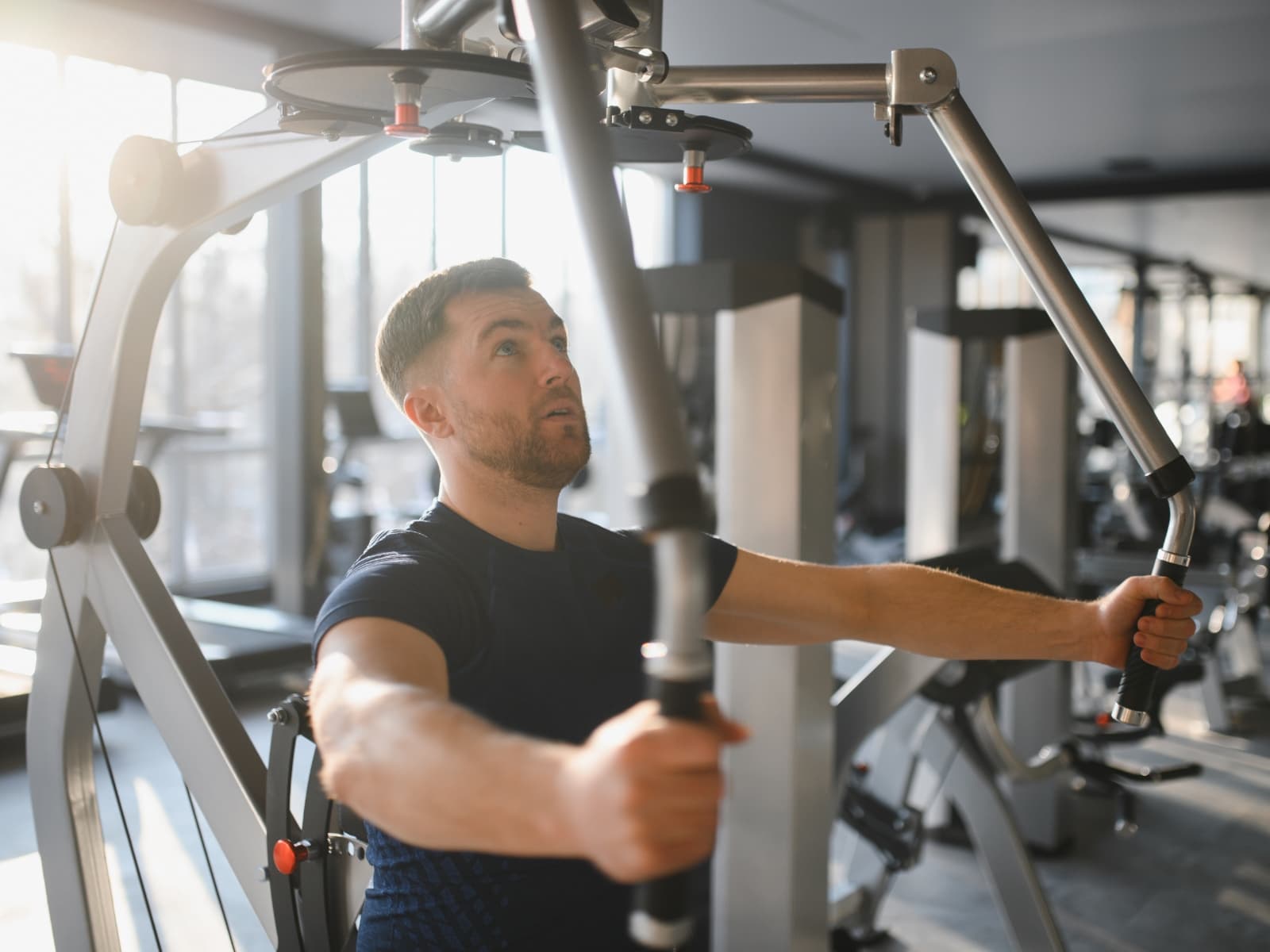 Man training arms on a gym machine